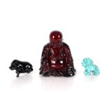 A Chinese cherry coloured amber type seated Buddha, holding fruit 6cm high; a  carved turquoise