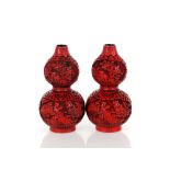 A pair of cinnabar lacquered style double gourd shaped vases, bearing gilt four character marks