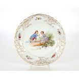 A Limoges style dinner service, decorated children at play and foliate scrolls heightened in gilt;
