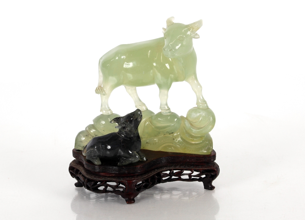 A Chinese carved Bowenite / hardstone study of a water buffalo, the largest beast standing upon