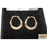 A pair of 9ct gold hoop ear-rings with silver deta