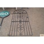 A wrought iron arch top garden gate