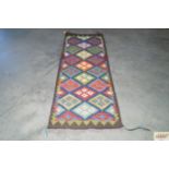An approx. 6'3" x 2'1" patterned rug