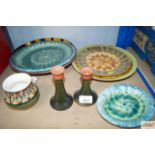 A quantity of studio pottery plates; a pair of green glazed studio candlesticks etc.