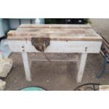 A wooden work bench with attached vice