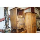 An oak linen fold panel bedside cupboard