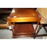 A reproduction mahogany two tier side table fitted