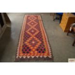 An approx. 9'8" x 3'2" red patterned rug