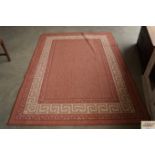 An approx. 7'5" x 5'4" red patterned rug