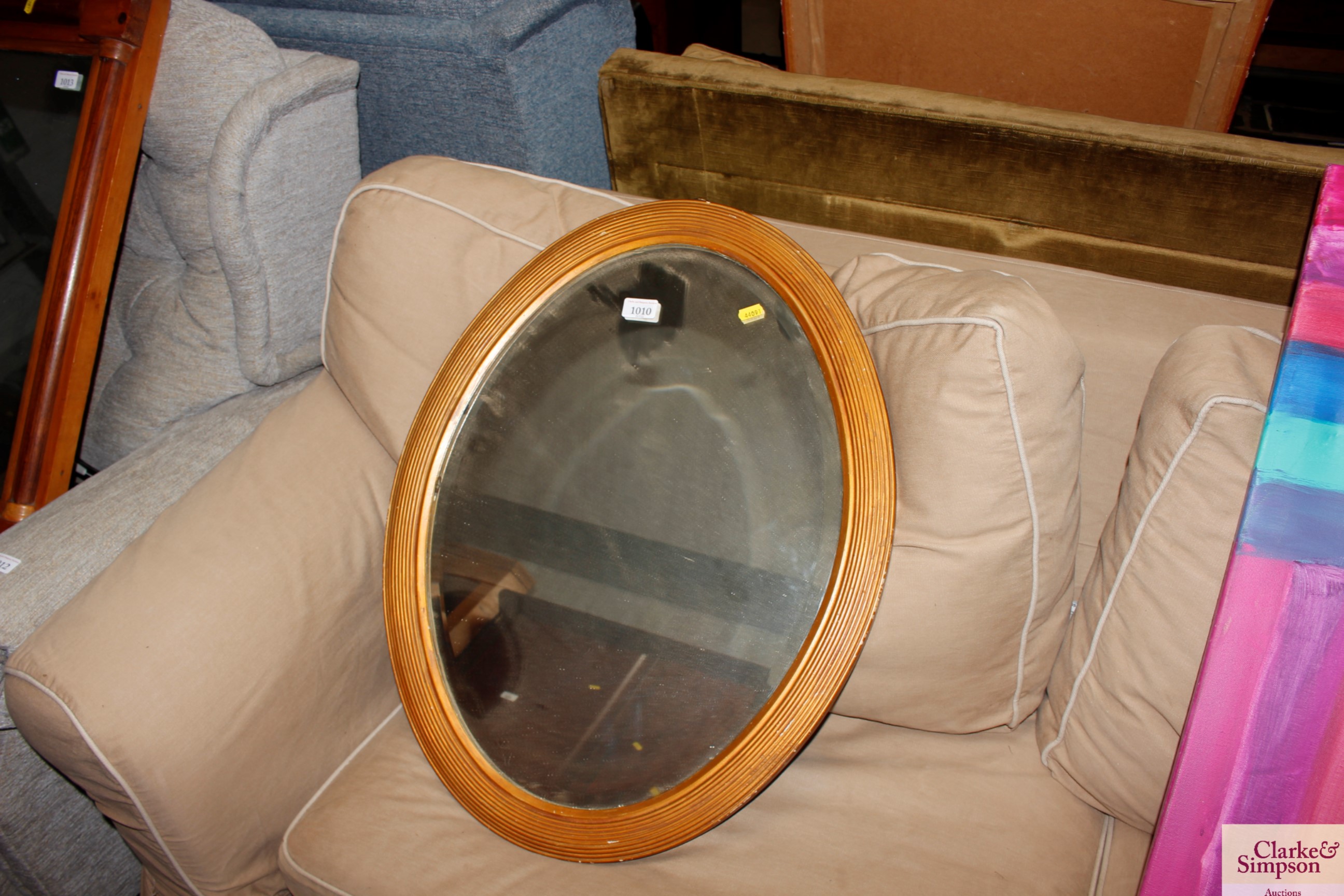 An oval framed bevelled edge wall mirror