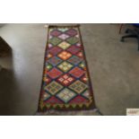 An approx. 6'3" x 2'1" patterned rug