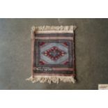 An approx. 1' square small patterned rug