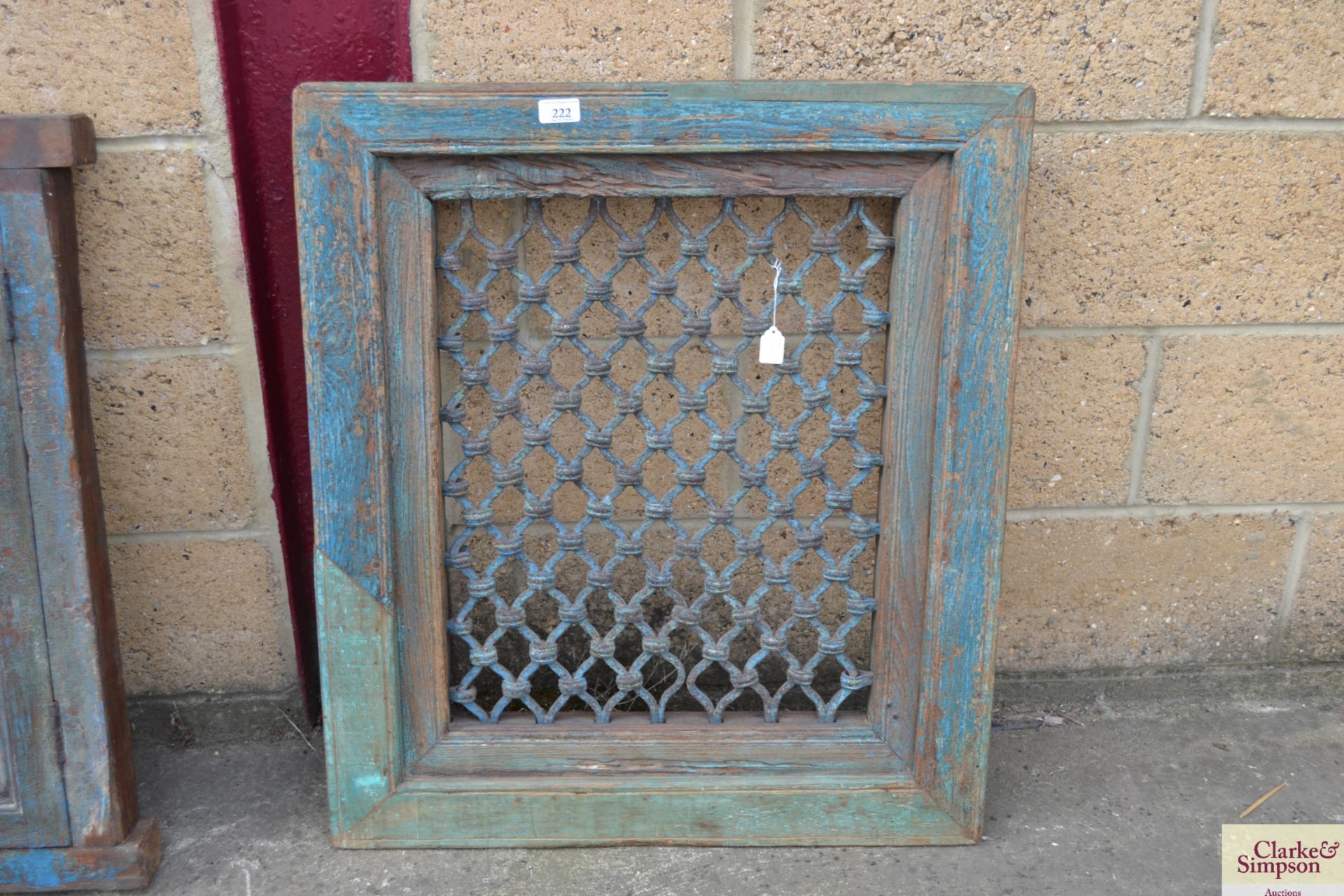 A wooden framed window with iron grill. V