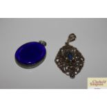 An oval blue stone pendant and an oval pierced whi