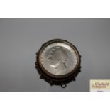 An antique silver coin in pendant mount