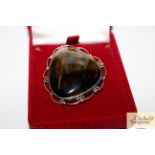 A large Sterling silver and tigers eye brooch