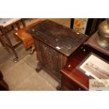 An antique carved oak side cupboard enclosed by si