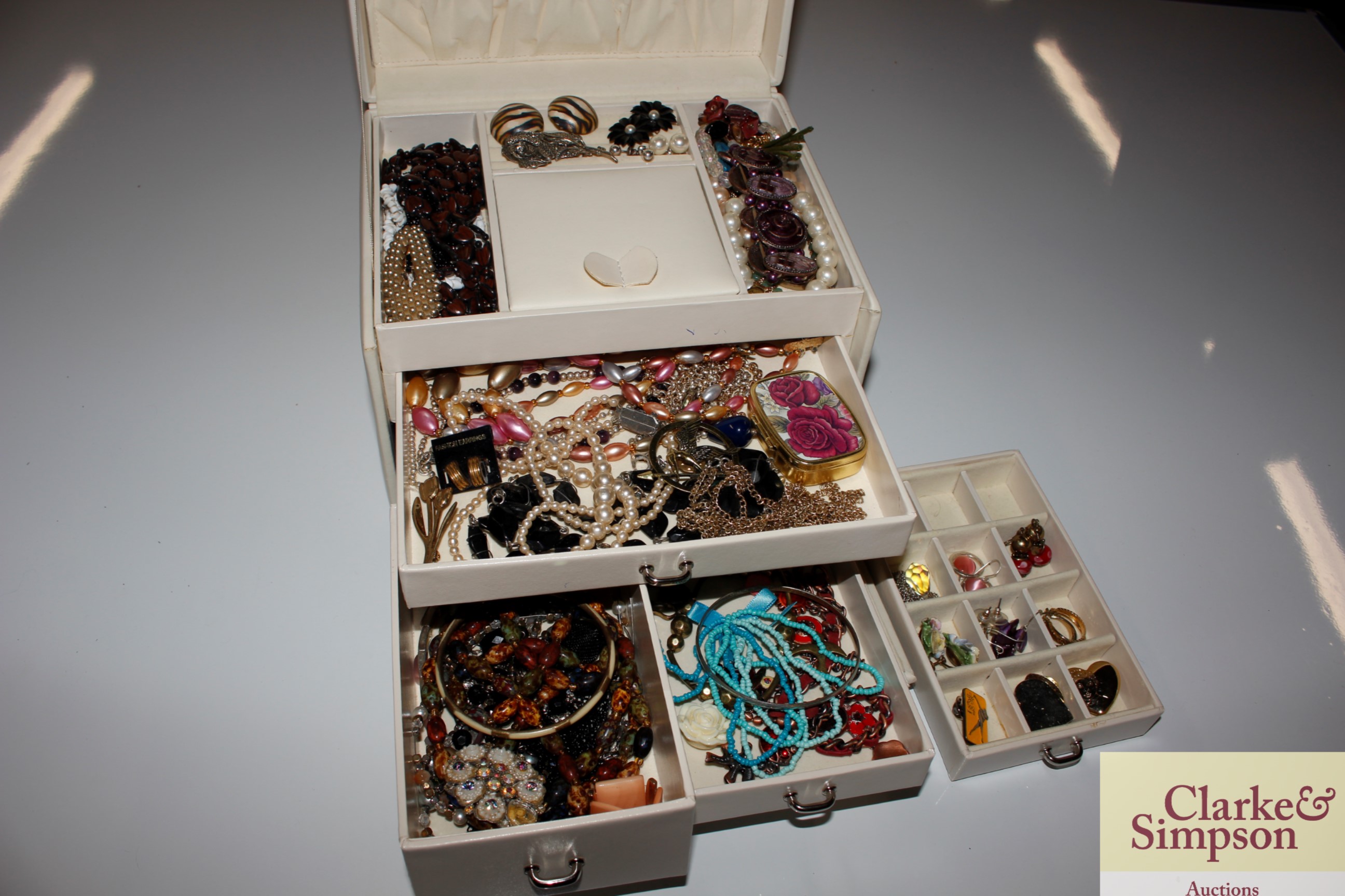 A cream coloured jewellery box and contents of var