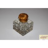 A Victorian glass inkwell with gilded metal top