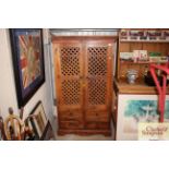 A modern hardwood cabinet enclosed by lattice door