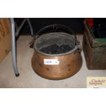 An antique copper cauldron with swing handle and c