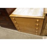 A retro lightwood chest of five drawers