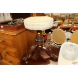 A Victorian carved walnut revolving piano stool