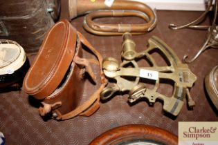 A brass sextant and a pair of leather case binocul
