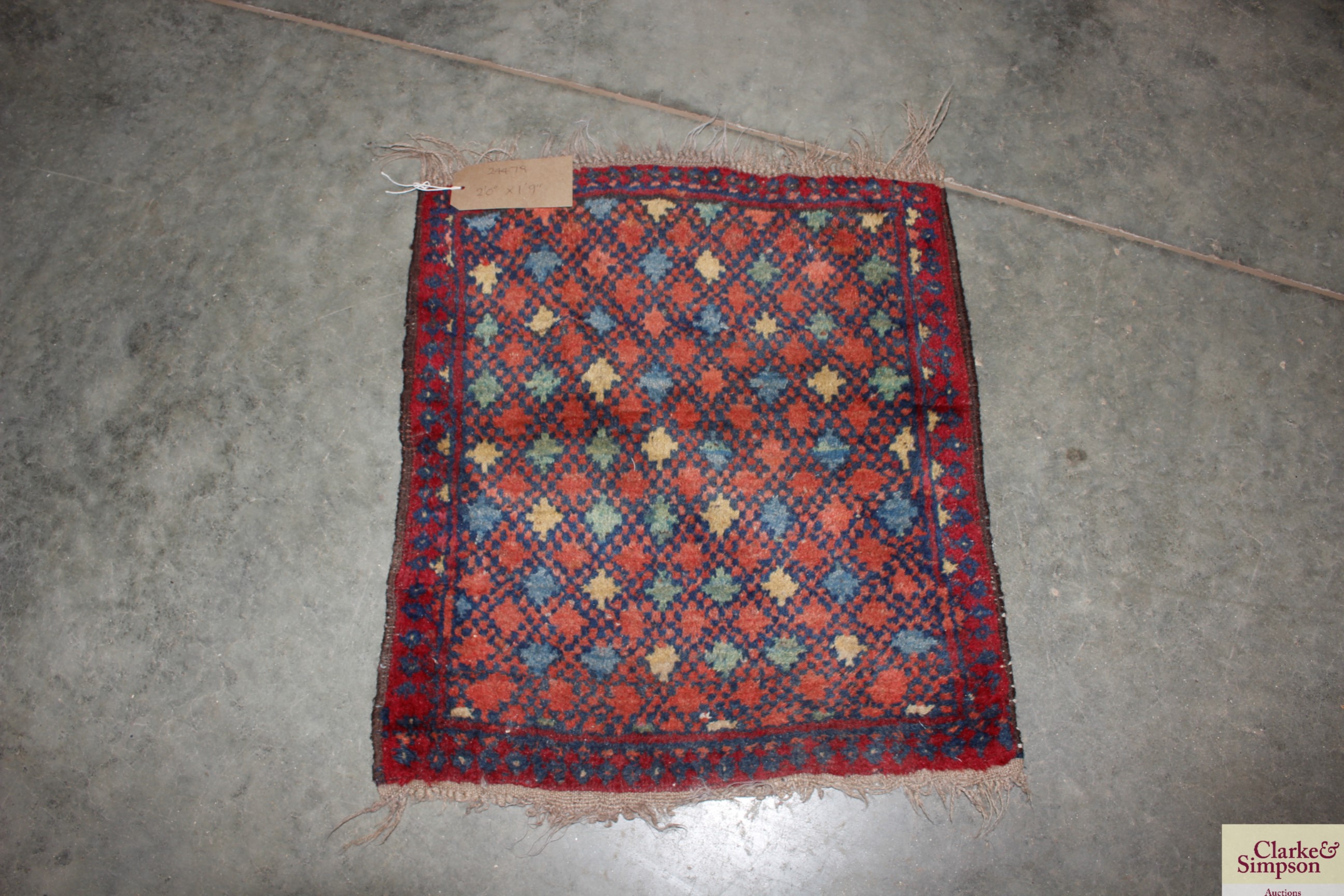 An approx. 2' x 1'9" red and blue patterned rug