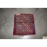 An approx. 2' x 1'9" red and blue patterned rug