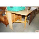 A melamine topped kitchen drop leaf table