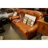 A leather upholstered three seater settee and matc