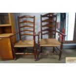 Two oak ladder back elbow chairs