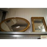 A gilt framed bevel edge oval wall mirror together