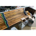 A wooden slatted garden bench with blue painted ca