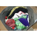 A bag containing various scarves, hats and bags et