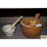 A wooden pestle & mortar together with one other
