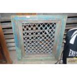 A wooden framed window with iron grill