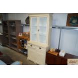 A painted display cabinet raised on cupboard base,