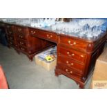 A reproduction mahogany partners desk with green l