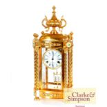 A large gilded four glass mantel clock, with urn a