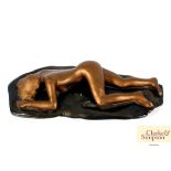 A glazed gilded plaster figure of a reclining nake