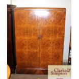 A 1930's walnut compactom wardrobe, having fully f