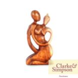 A Henry Moore style wooden sculpture of a naked ma