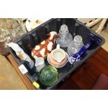 A plastic crate containing cut glass bottles and s