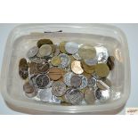 A plastic tub containing miscellaneous coins and t