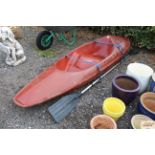 A fibreglass kayak and oar