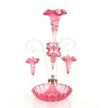 A Victorian cranberry glass epergne, having trumpet shaped vases with frilled rims, hanging