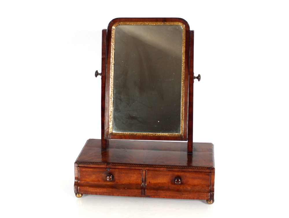 A Georgian walnut swing toilet mirror, the arched plate with gilt surround raised on tapering