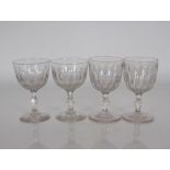 Four Victorian glasses of large size with thumb press decoration and faceted stems